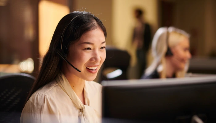 Customer service colleagues using headsets at their desks
