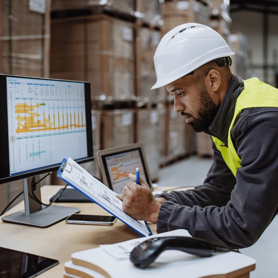 Warehouse colleague reviewing inventory on a handheld device